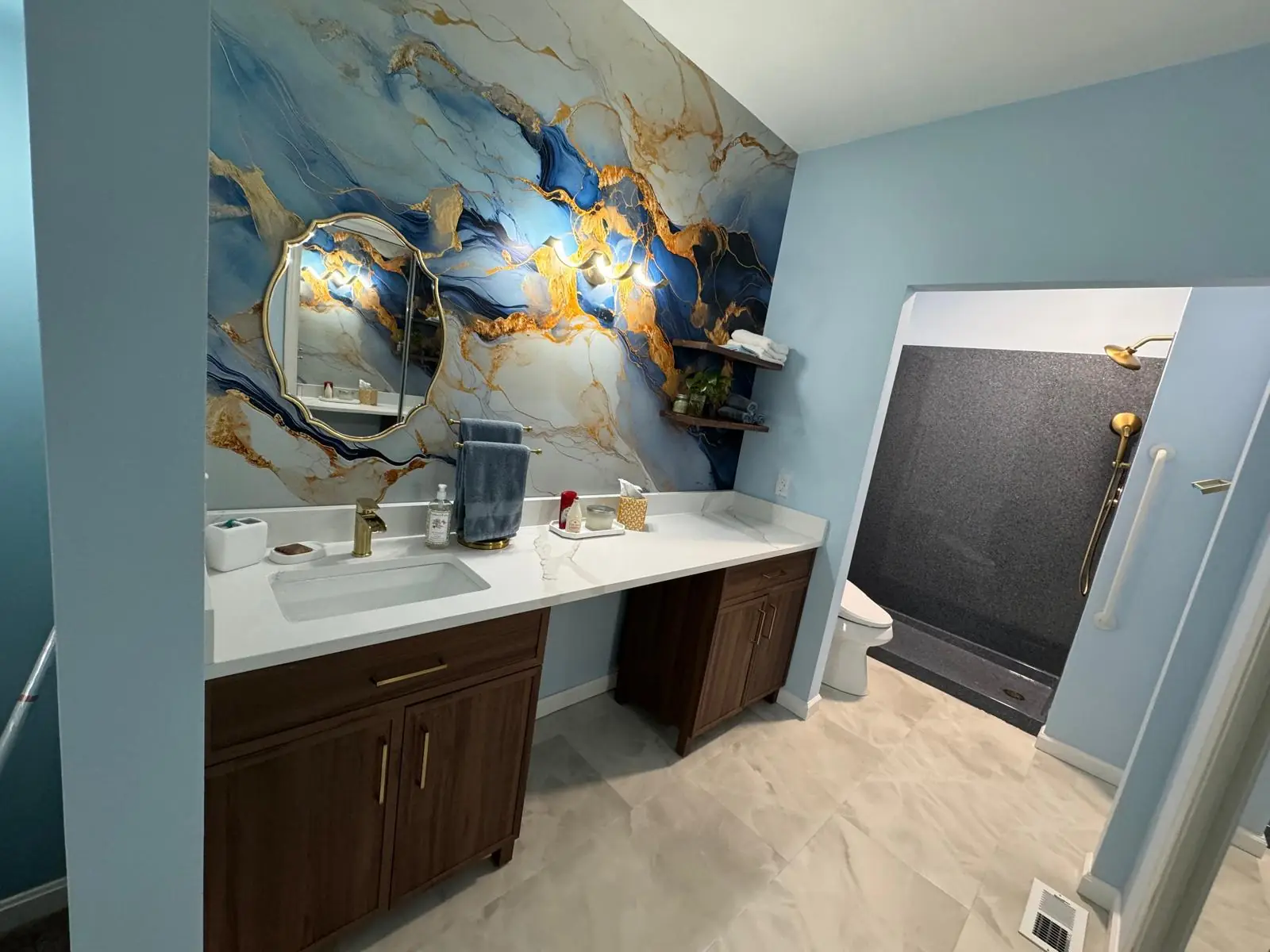 Bathroom with a blue and gold marble mural wall above a long vanity