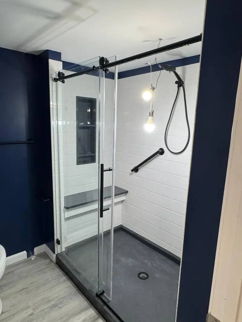 Walk-in shower with a sliding glass door and white subway tile