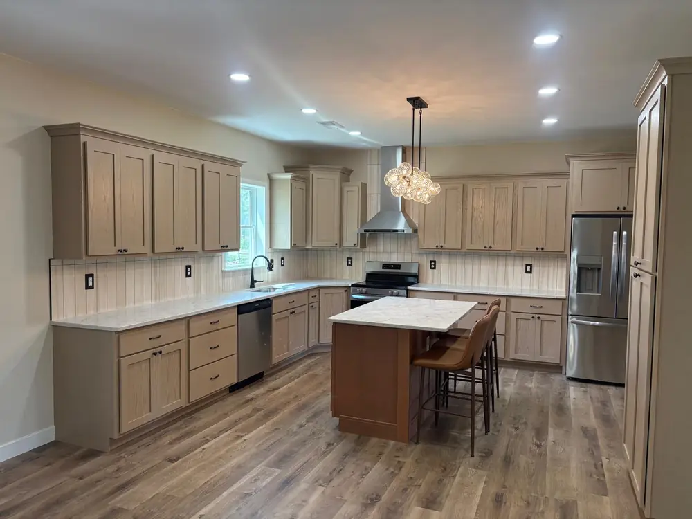 Kitchen with wood-tone cabinets, a breakfast bar island and pendant light
